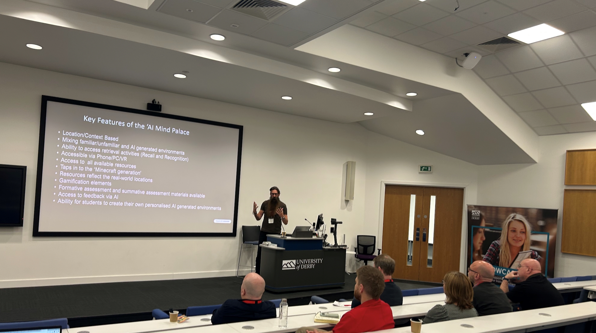Man with big beard talking an audience in a lecture theatre