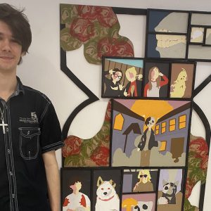 Young student stood in front of a piece of art.