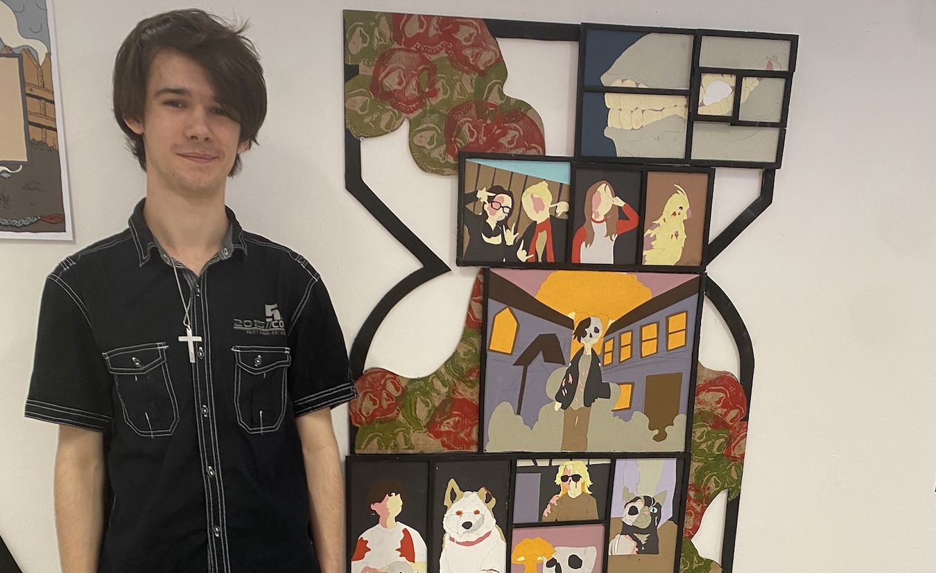 Young student stood in front of a piece of art.