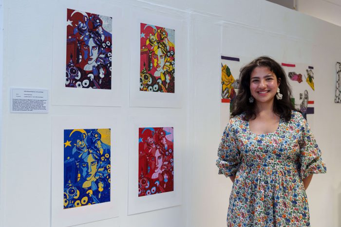 Young students stood by pieces of art on the wall.