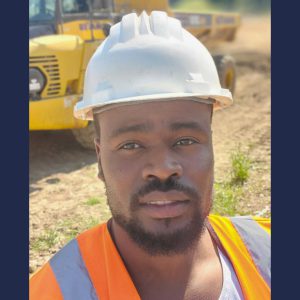 Man wearing a hard hat and hi-vis on a construction site.