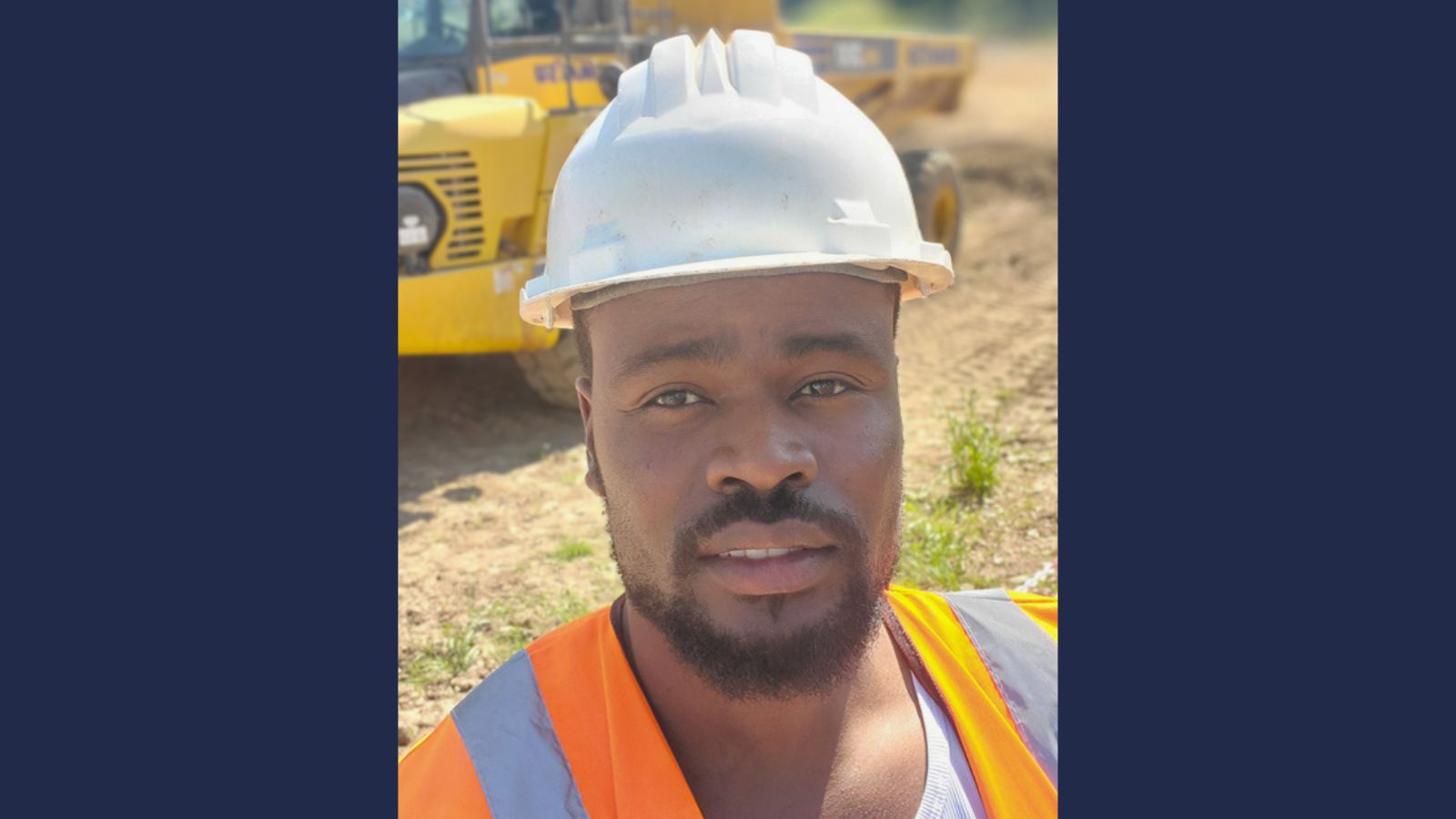 Man wearing a hard hat and hi-vis on a construction site.