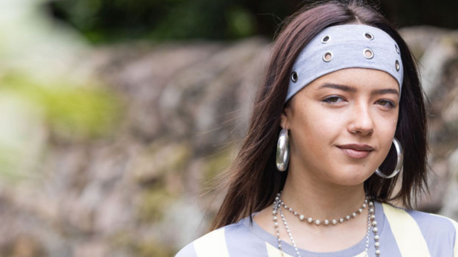 Art student Liana, a young student wearing a blue and white striped shirt and a blue bandana.