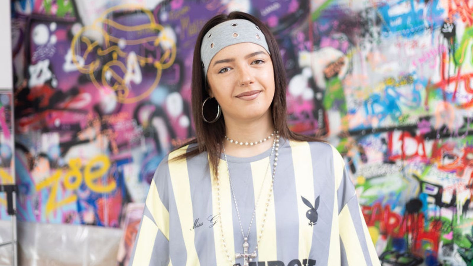 Art student Liana, a young student wearing a blue and white striped shirt and a blue bandana.
