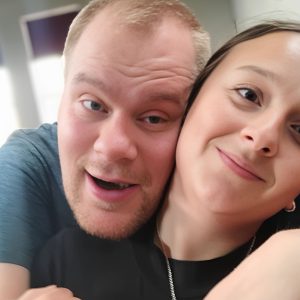 Smiling young man and smiling young woman posing for a selfie.