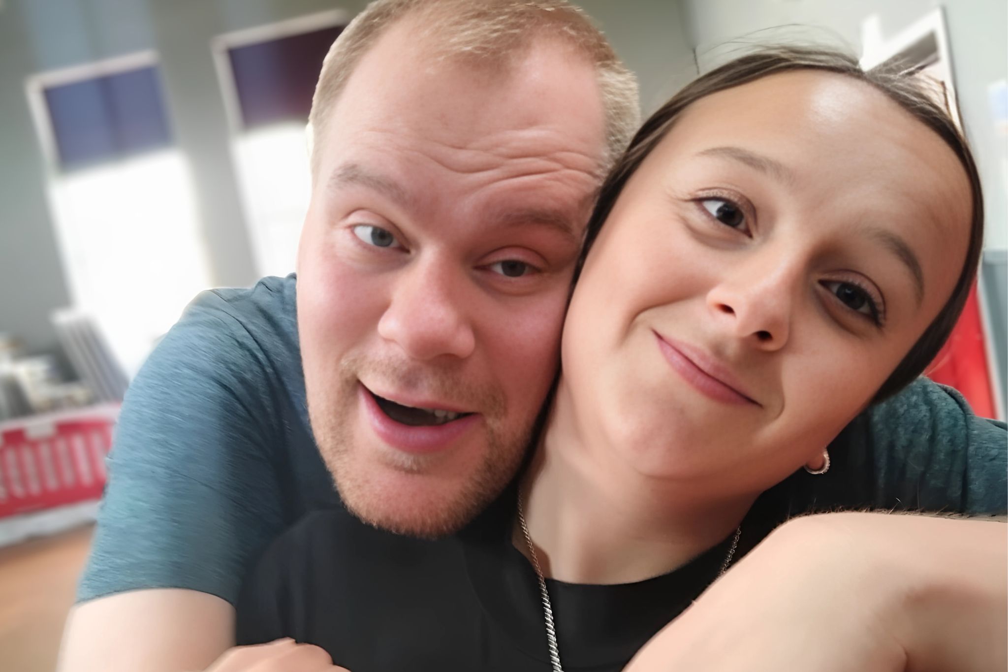 Smiling young man and smiling young woman posing for a selfie.