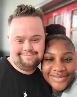 Young man and young woman smiling for a selfie.