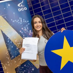 Young student with dark hair holding a card with a star on it.