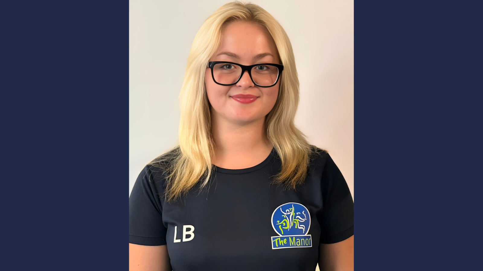 Student with blonde hair and glasses wearing a sports jersey.