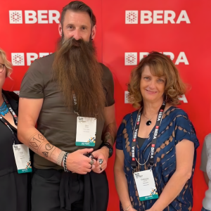 Four DCG teachers stood by a red background.