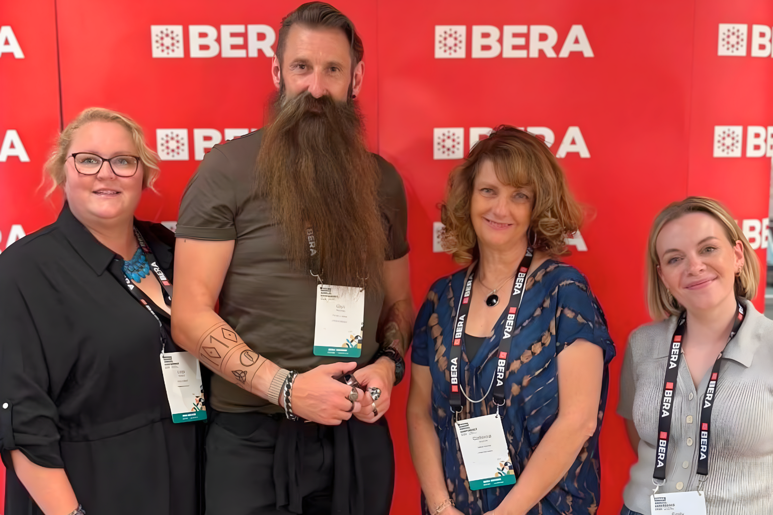 Four DCG teachers stood by a red background.