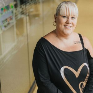 Adult with blonde hair and a black top at the Roundhouse.