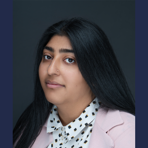 Young person with dark hair and a white shirt with a pattern.