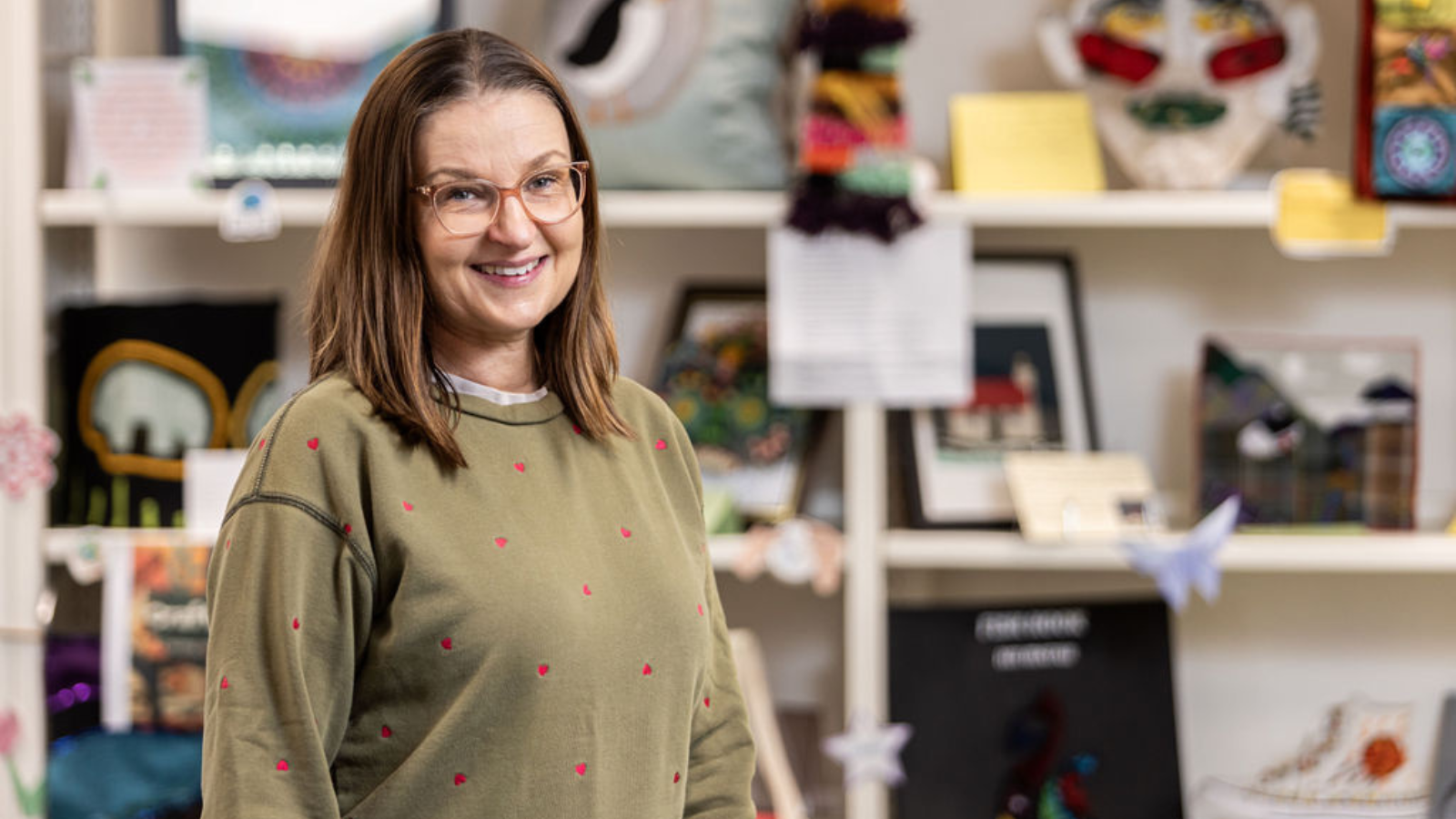 Adult learning and upcycling student Kathryn stood in-front of a big display of crafted items.