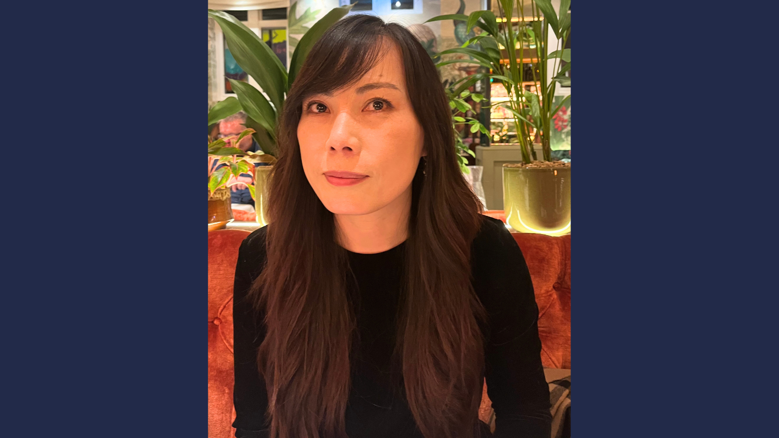 Person with long dark hair and a black top.