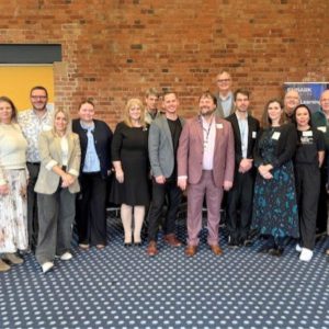 A group of students and local business representatives standing together at the Derby College Group networking event, showcasing employer engagement and real‑world employability skills.