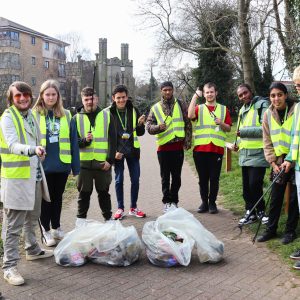 Students volunteering to collect litter wearing hi-viz vests.