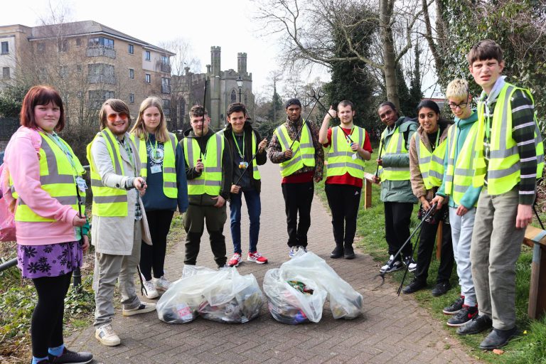 Students volunteering to collect litter wearing hi-viz vests.