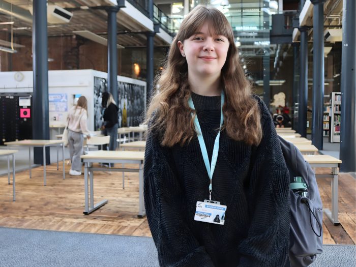 Student wearing a black jumper and blue lanyard.