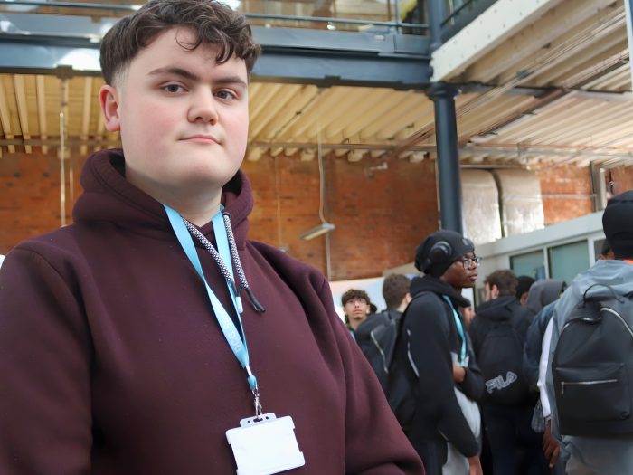 Student wearing a purple jacket and blue lanyard.