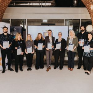 A big group of Derby College Group teachers holding their certificates.