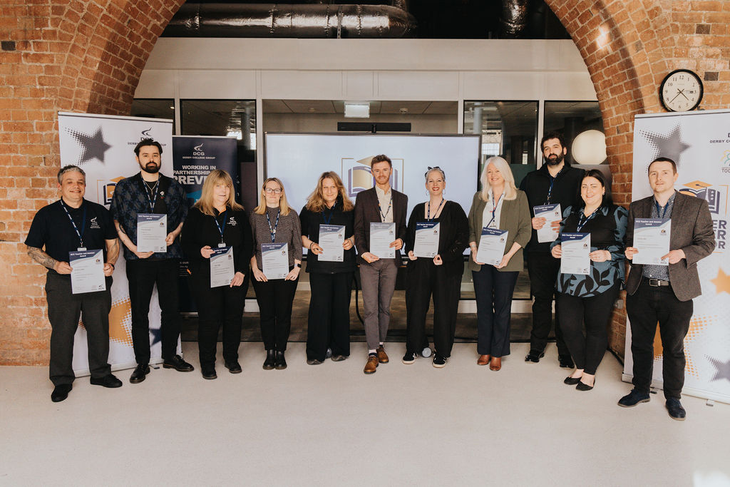 A big group of Derby College Group teachers holding their certificates.