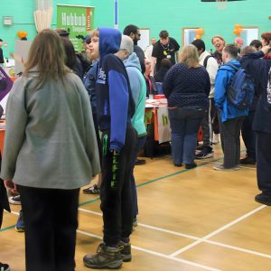 Attendees gather around exhibitor stalls inside the Inclusion Showcase 2026 venue, engaging in conversations and exploring opportunities from community organisations.
