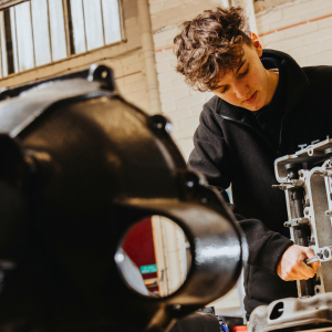 Derby College Group T Level student using engineering machinery.