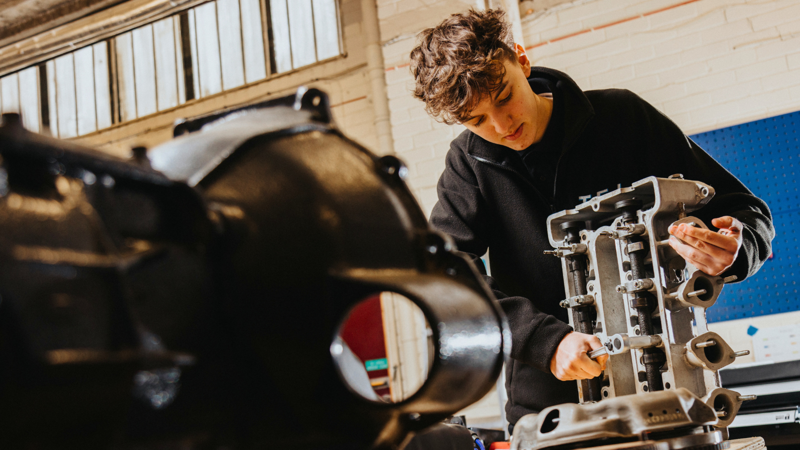 Derby College Group T Level student using engineering machinery.