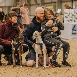 Visitors with dogs posing together at an indoor dog festival event at Broomfield Hall.