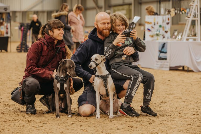 Visitors with dogs posing together at an indoor dog festival event at Broomfield Hall.