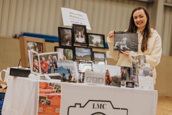 Stall displaying printed photographs and offering a photoshoot at an indoor event at Broomfield Hall.