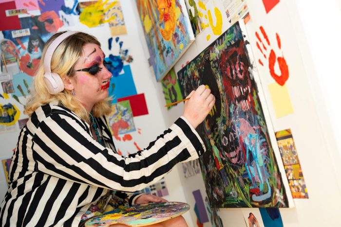 A Derby College student creates bold, expressive artwork as part of the Creative & Digital Exhibition in Derby.