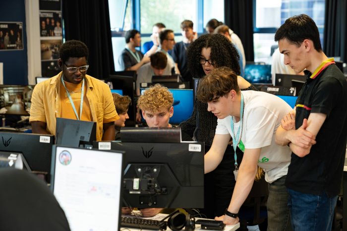 Digital media students collaborating on computers in a classroom at Derby College