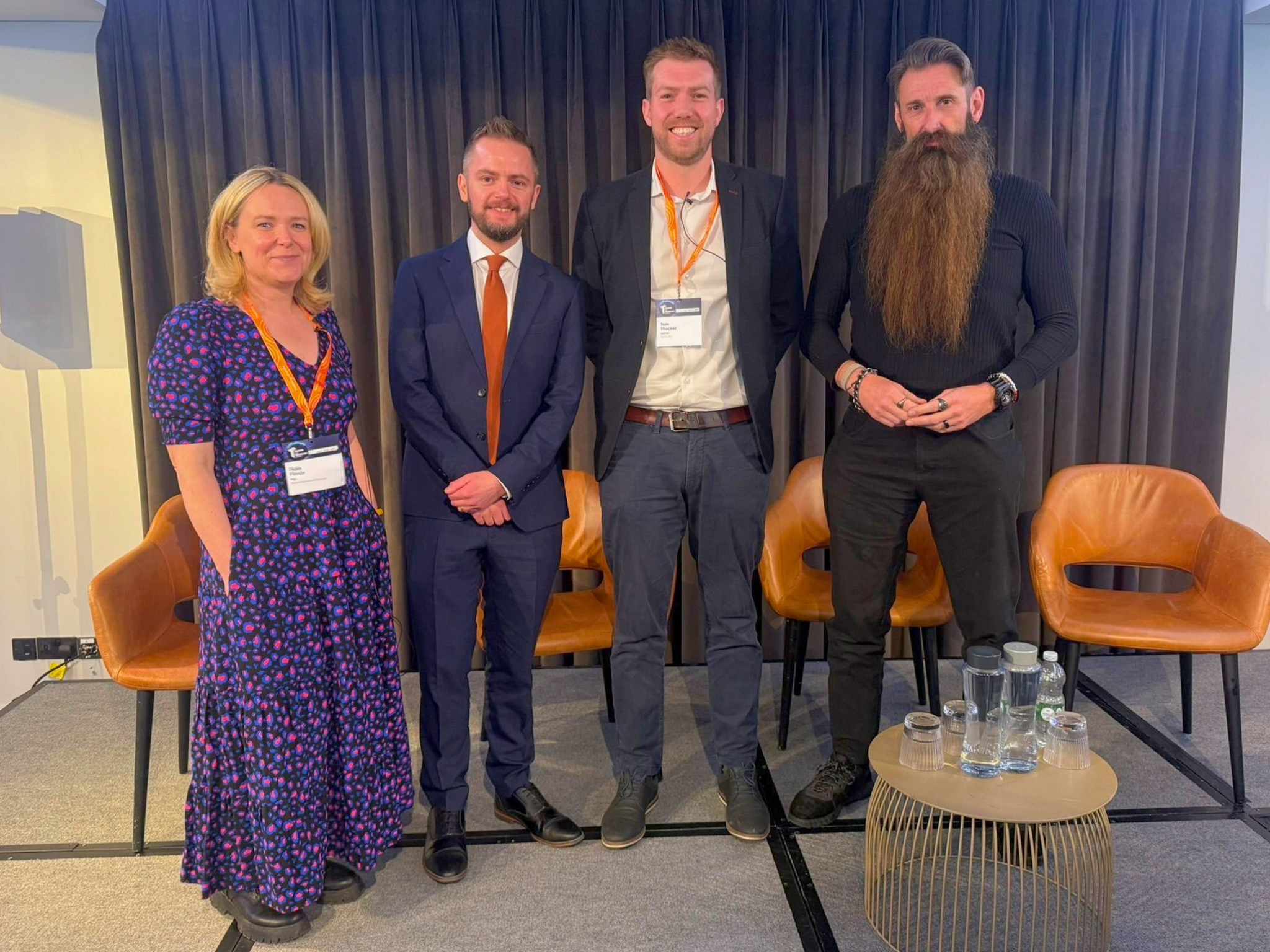 Panel speakers standing on stage during an education and technology discussion at the Training and Technology Summit in London.