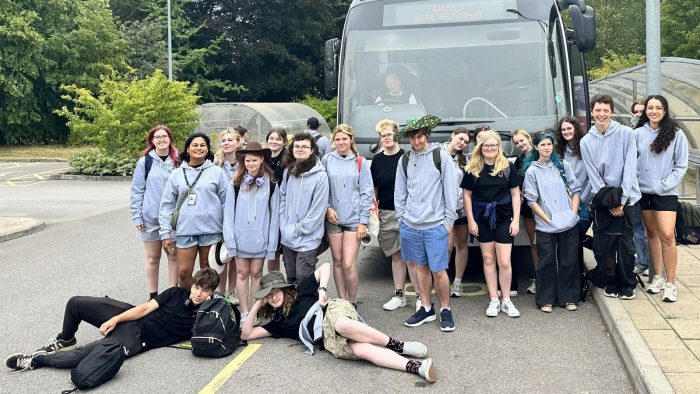 Derby College Animal Care students sat in front of a coach.