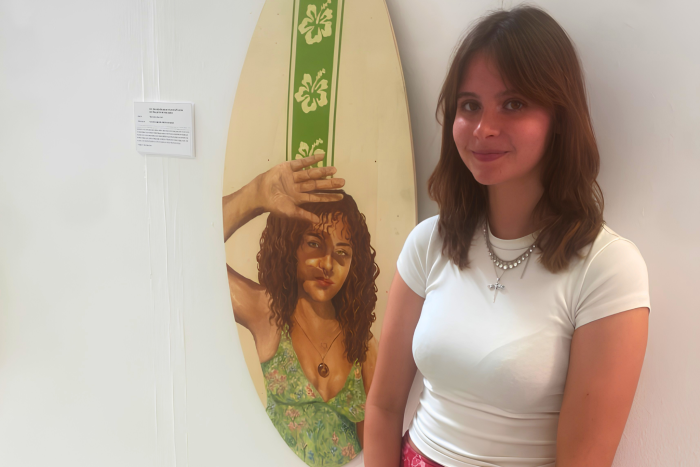 Ella-Rose Wadsworth standing beside part of her surf culture-inspired artwork display after being named joint winner of the Bryan Harris Bursary at Derby College Group.