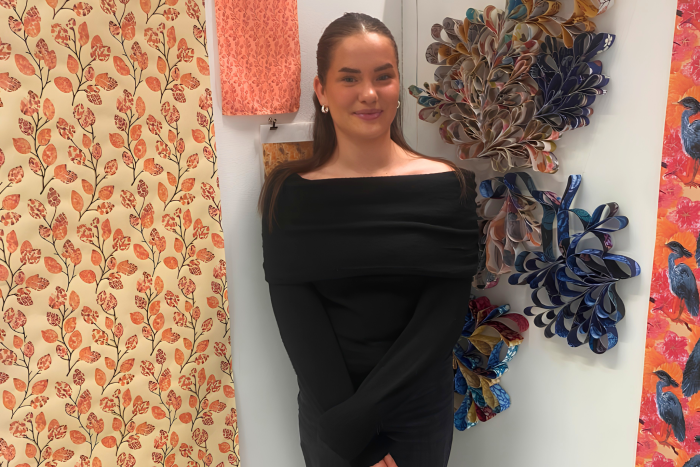 Katy Pendleton standing with her Japanese-inspired surface design and wallpaper display after winning the Bryan Harris Bursary at Derby College Group.