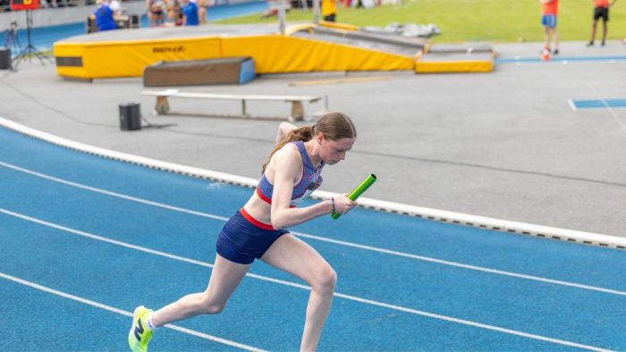 Caitlin competing with the relay baton during the women's 4x400m event at the Mannheim Juniors Gala.