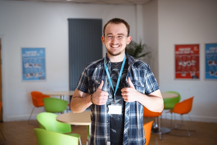 A-level student Campbell Griffin holding both thumbs up on Results Day.