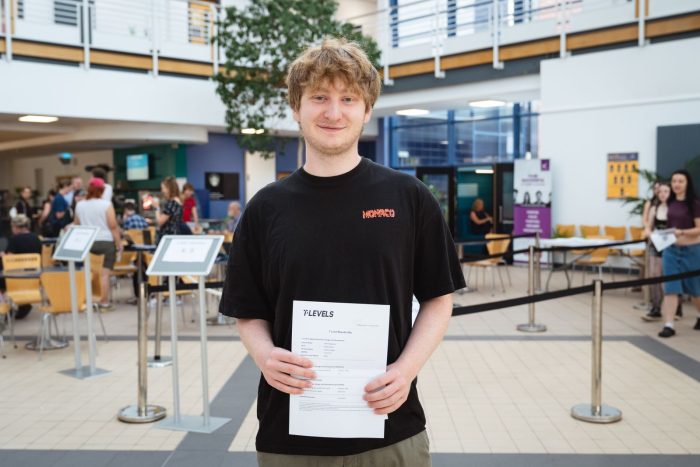 Derby College T Level student Rafe Neighbour holding their results.