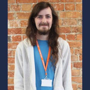 Former Derby College student Adrian Pruchniki wearing an orange lanyard and a blue shirt with a grey sweater