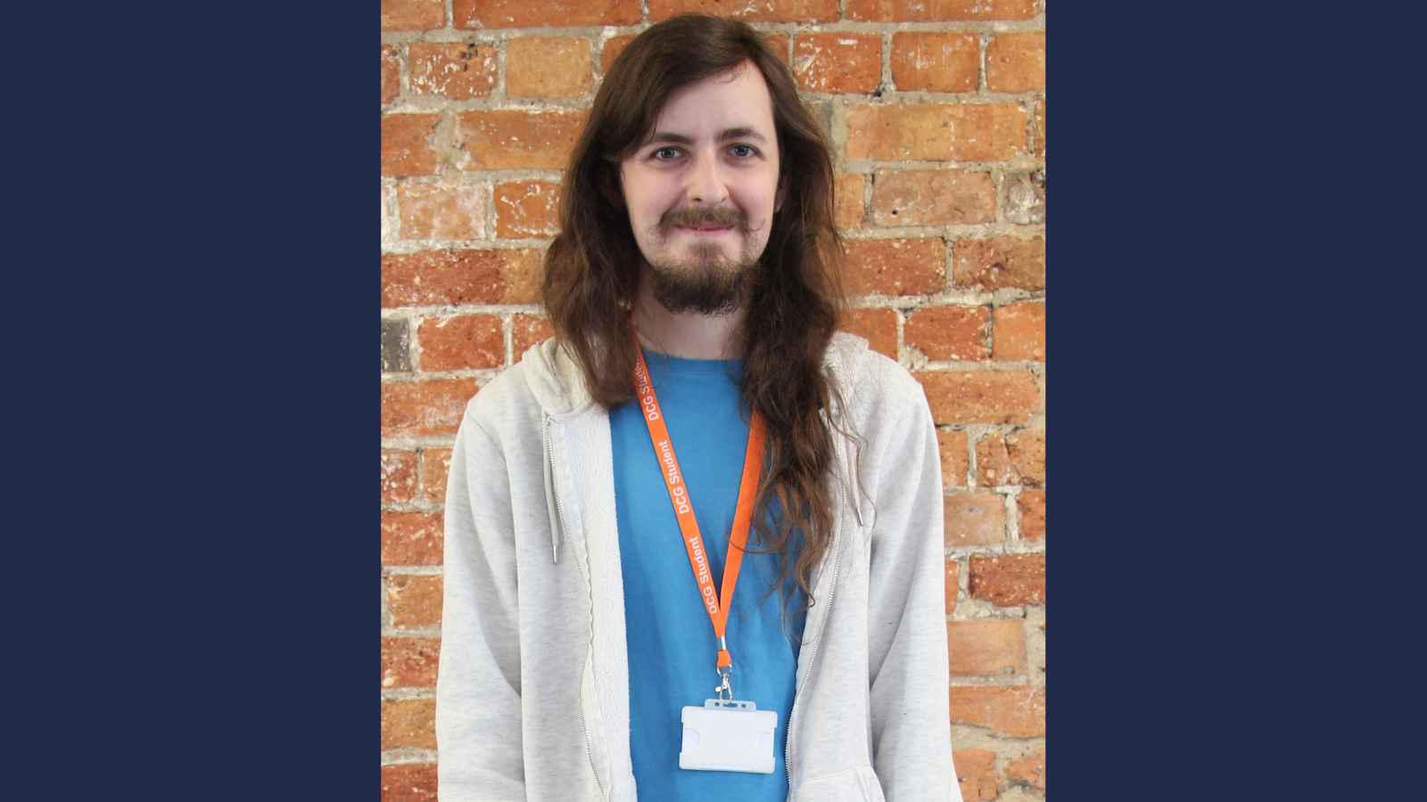 Former Derby College student Adrian Pruchniki wearing an orange lanyard and a blue shirt with a grey sweater