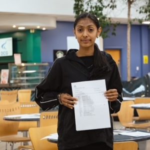 Rajasi Soni, a Derby College student holding her results paper at the Joseph Wright Centre.