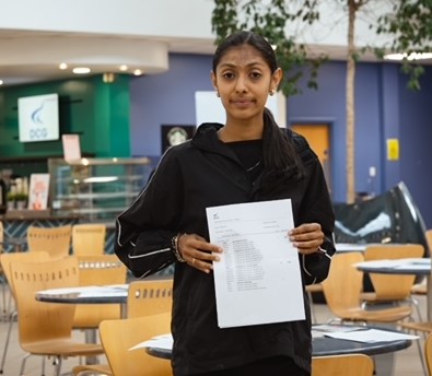 Rajasi Soni, a Derby College student holding her results paper at the Joseph Wright Centre.