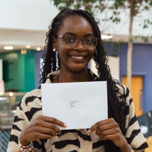 GCSE Plus student Keisha Katambe holding a piece of paper at Derby College's Joseph Wright Centre