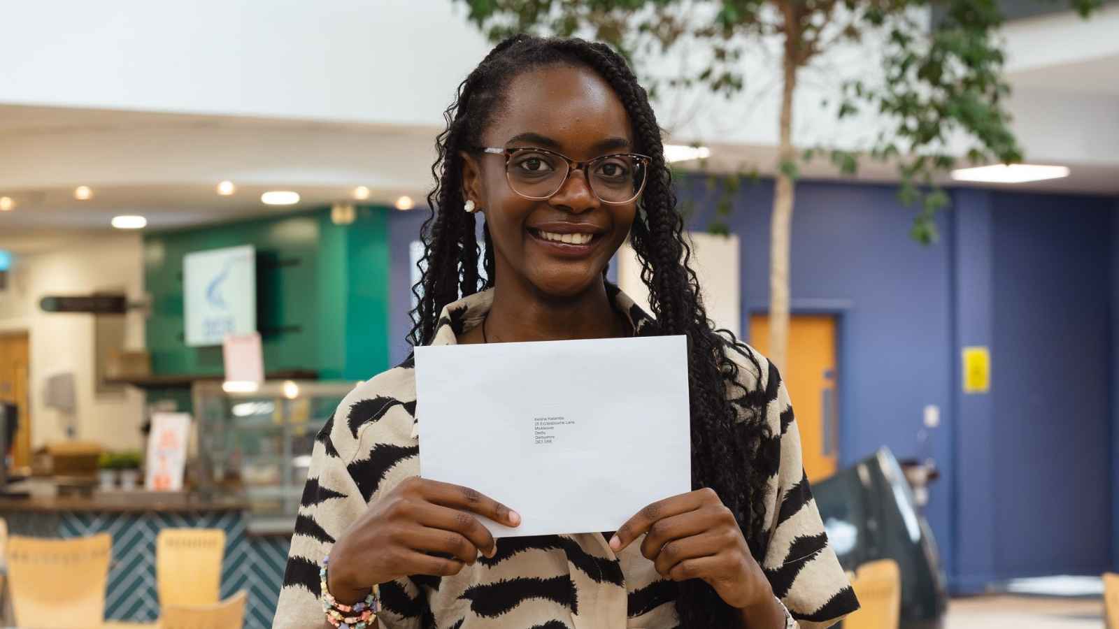 GCSE Plus student Keisha Katambe holding a piece of paper at Derby College's Joseph Wright Centre