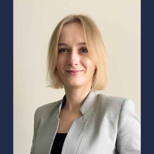 Adult learner Oksana Hayhar wearing a grey suit jacket and black shirt