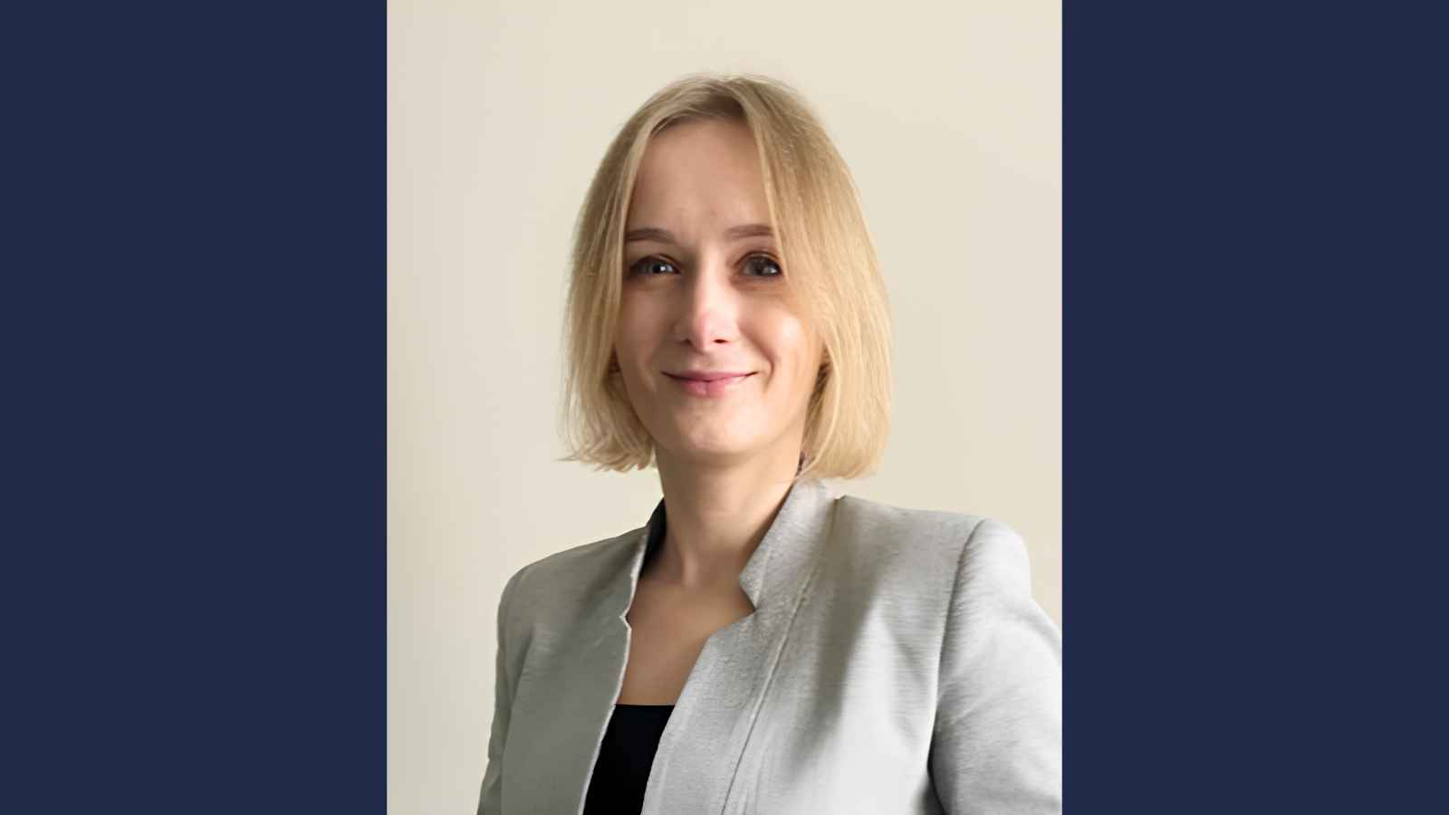 Adult learner Oksana Hayhar wearing a grey suit jacket and black shirt
