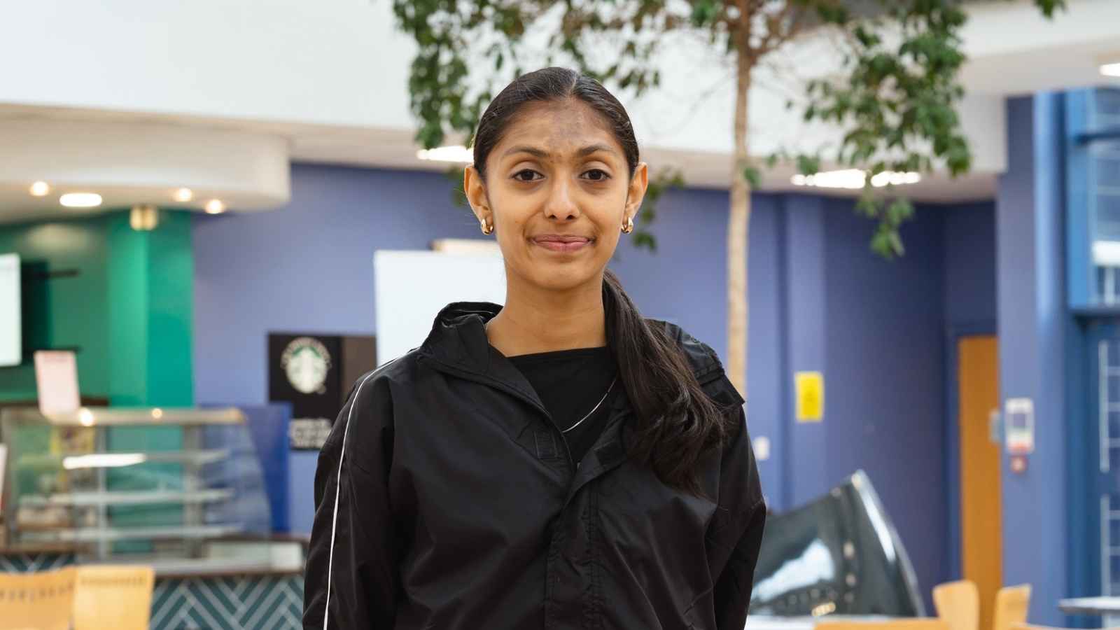 Rajasi Soni, a Derby College student holding her results paper at the Joseph Wright Centre.